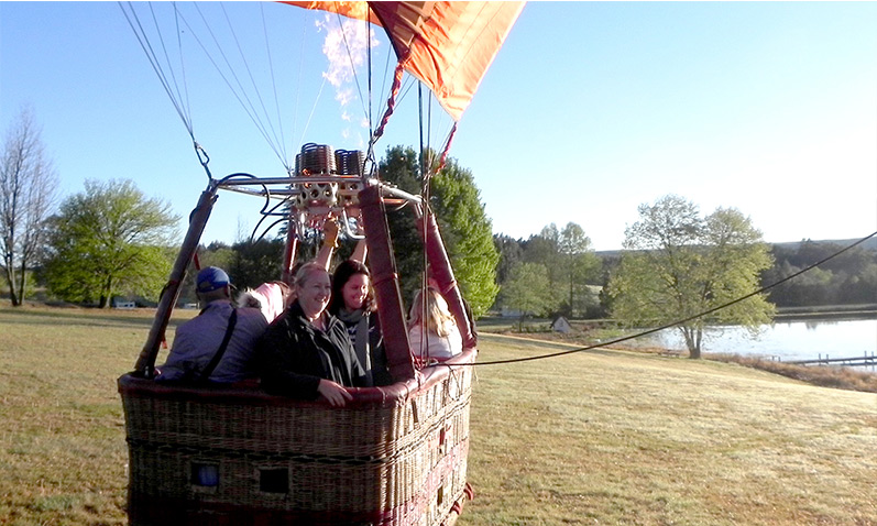 Pilot and passengers about to take off for a hot air balloon flight.
